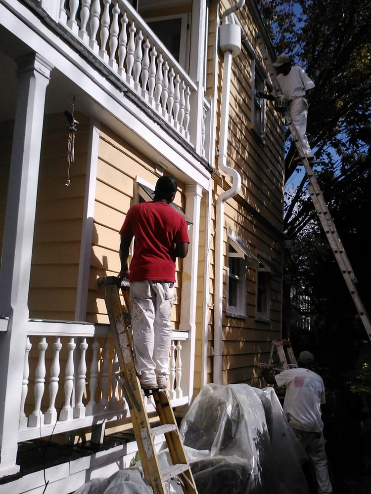 Cobbs Painting full crew painting a yellow home exterior